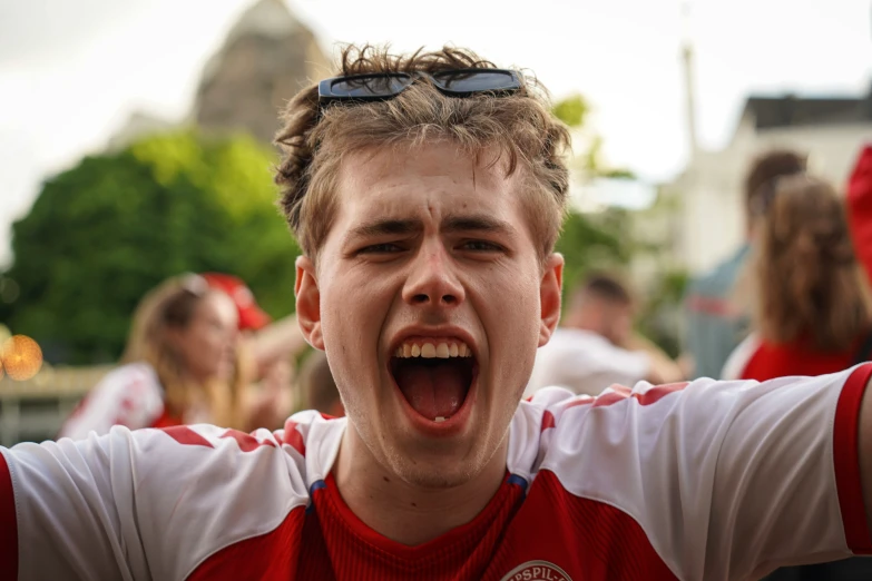 a young man with his mouth open in front of people