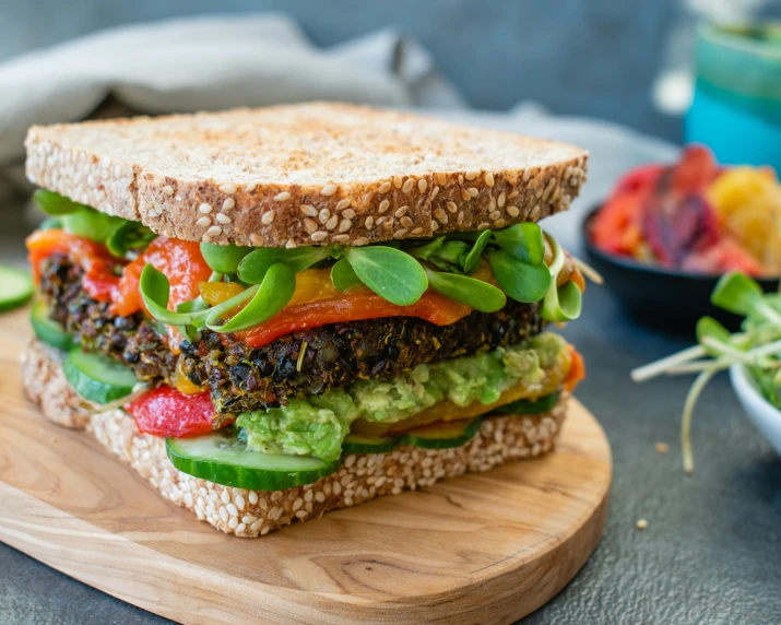 the large vegetable sandwich is on a wooden board