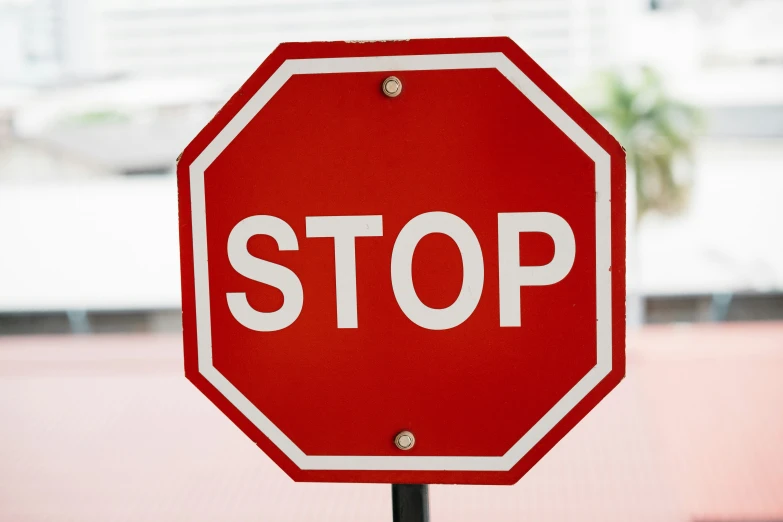 a red stop sign sitting on top of a metal pole