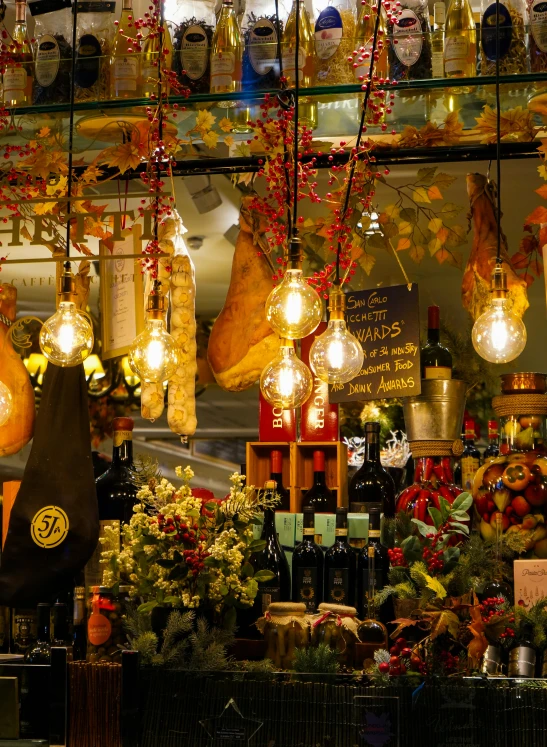 lighted bottles and bulbs hang from a display in a store window