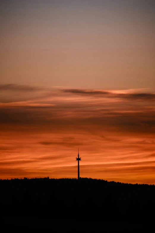 there is a very tall cross at sunset