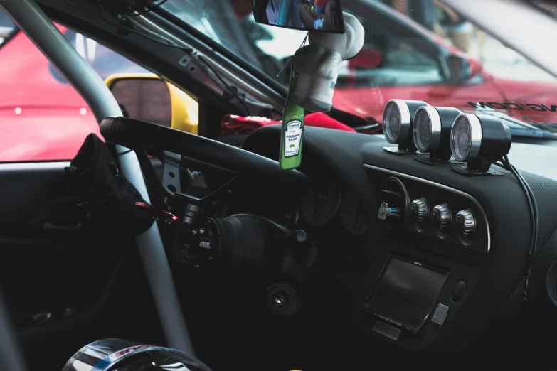 a black car has a green canister in the dashboard