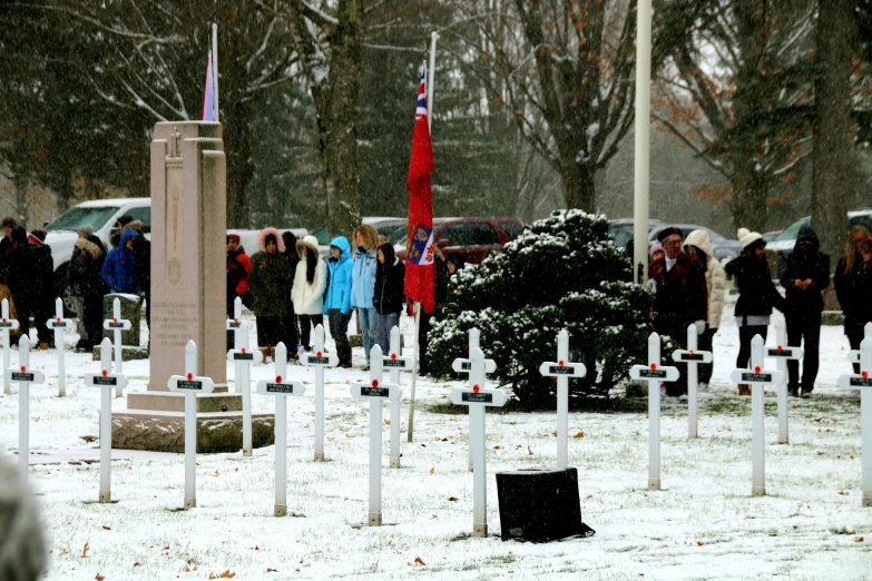 some people are in the snow near many graves