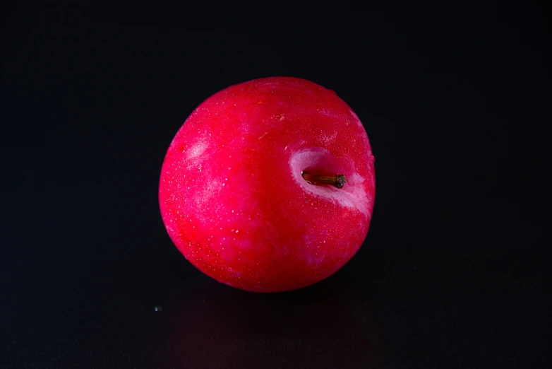 an apple is shown on a dark black background