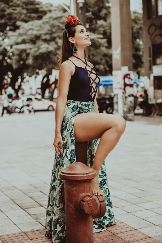 a beautiful woman in a skirt leaning up against a fire hydrant