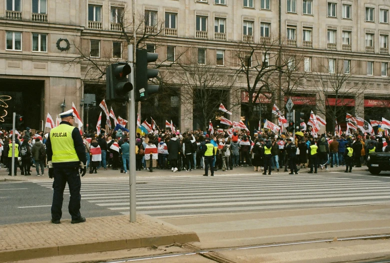 a large group of people with flags gathered on a street corner