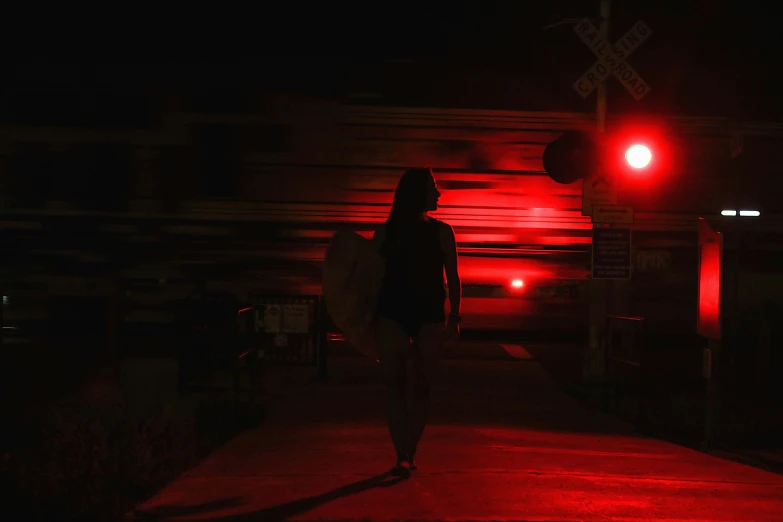 a dark and scary po shows a woman walking across the street with a red traffic light