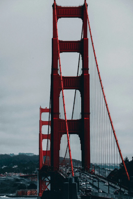 a large bridge with red poles going across a body of water