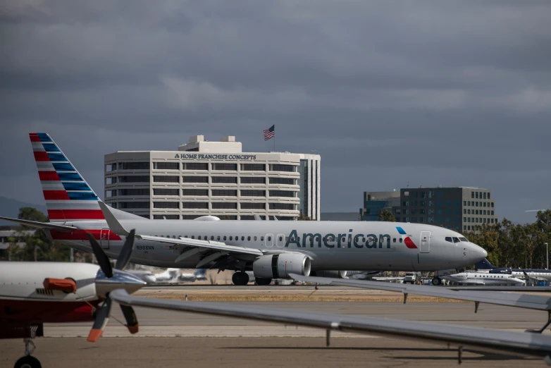 american airlines jet on runway at airport against cloudy sky