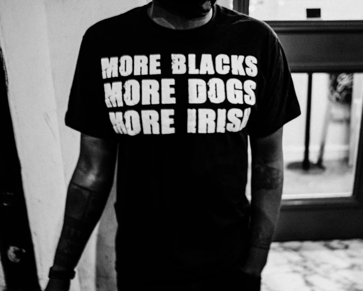a man with a black t - shirt has a white letter on it