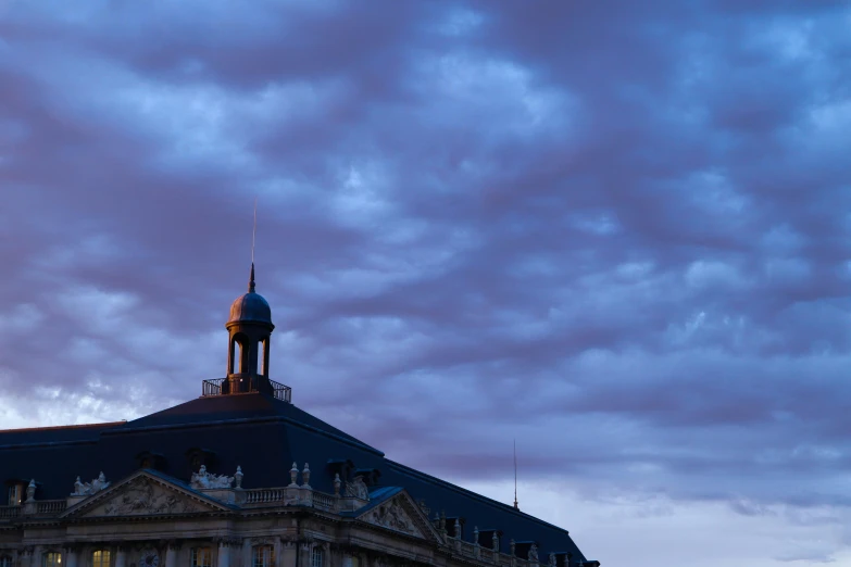 an ornate building with clock tower lit up under a cloudy sky