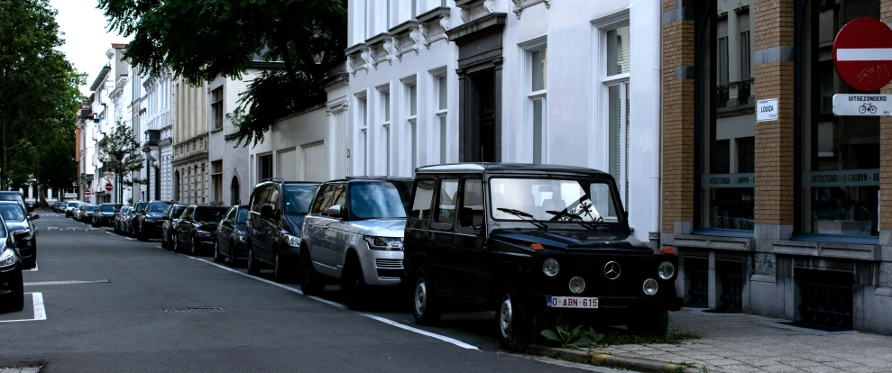 parked cars and an open van line the street