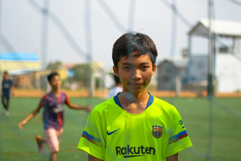 a boy is standing in front of a soccer net