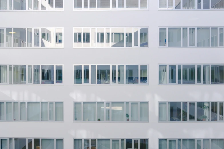 large, empty white building with windows reflecting street lights