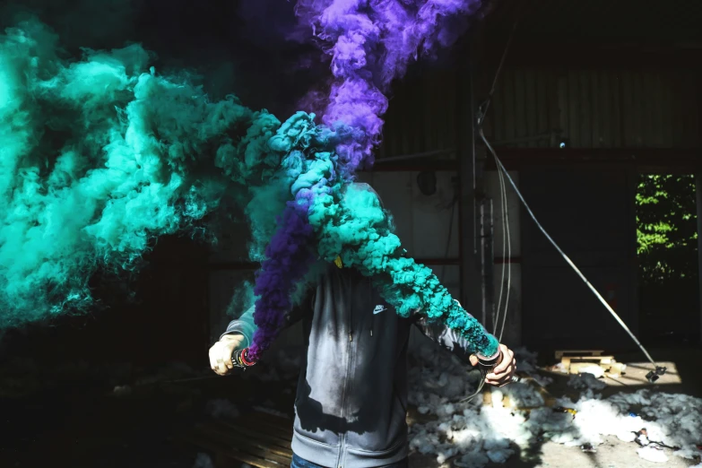 a young man holding a colorful pipe in his hands