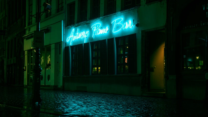 a neon sign for a bar lit up at night