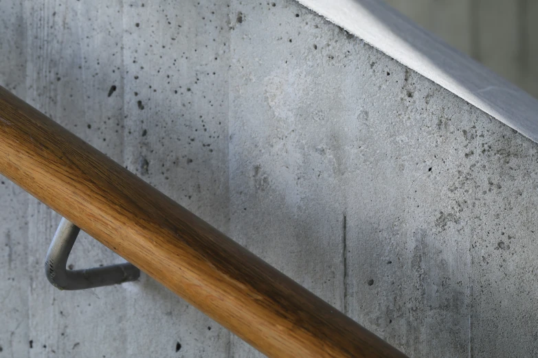 metal and wood railing against wall with cement