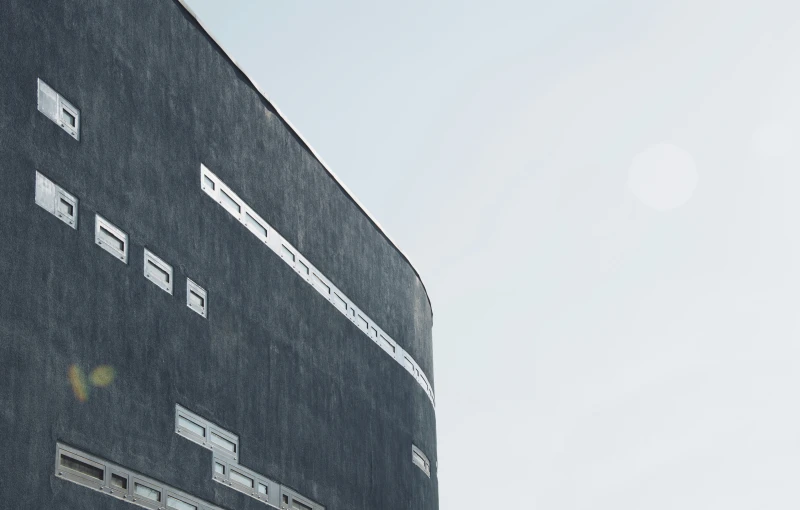 a view of the corner of a building with several types of windows on the side