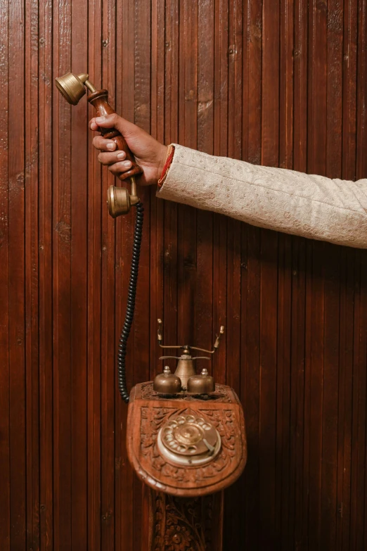 a person holding two old style antique telephones