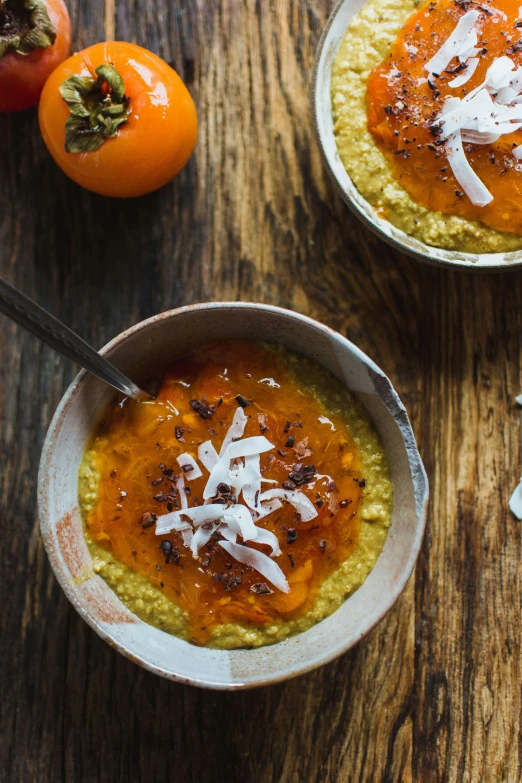 two bowls of soup, with two spoons, on a table