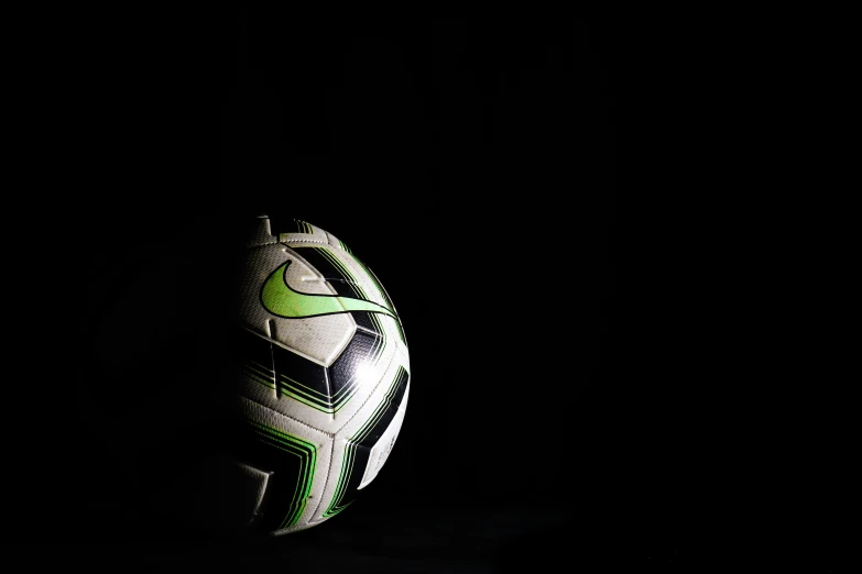 a soccer ball sits in the dark on the floor