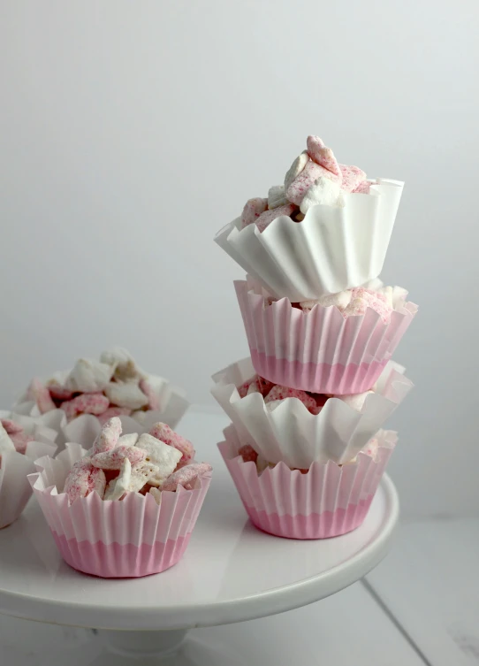 three pink and white cups with pink toppings