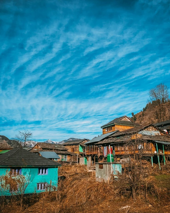 blue sky over wooden shacks on the side of a hill