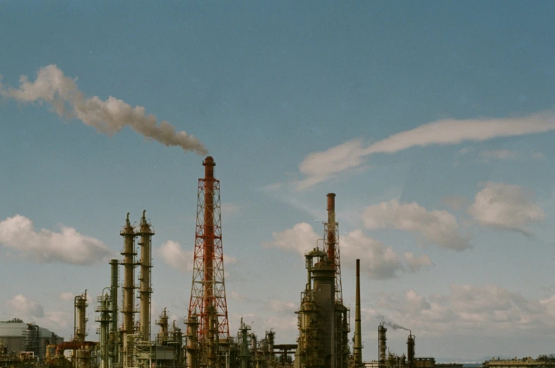 a large industrial factory with smokestacks and towers