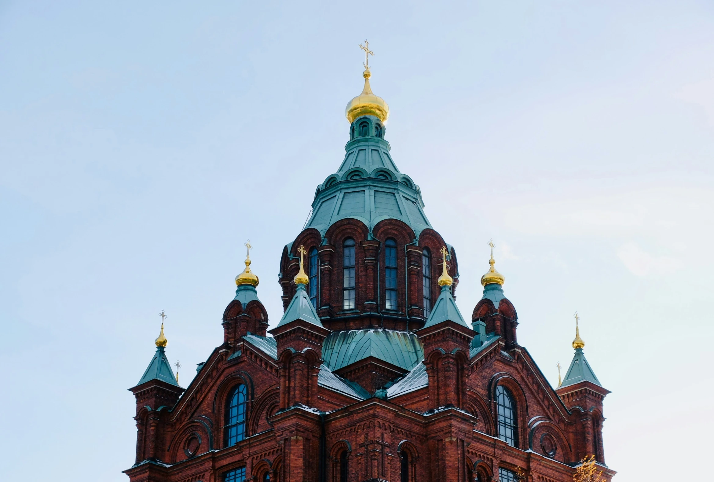 an ornate building has domes on the roof