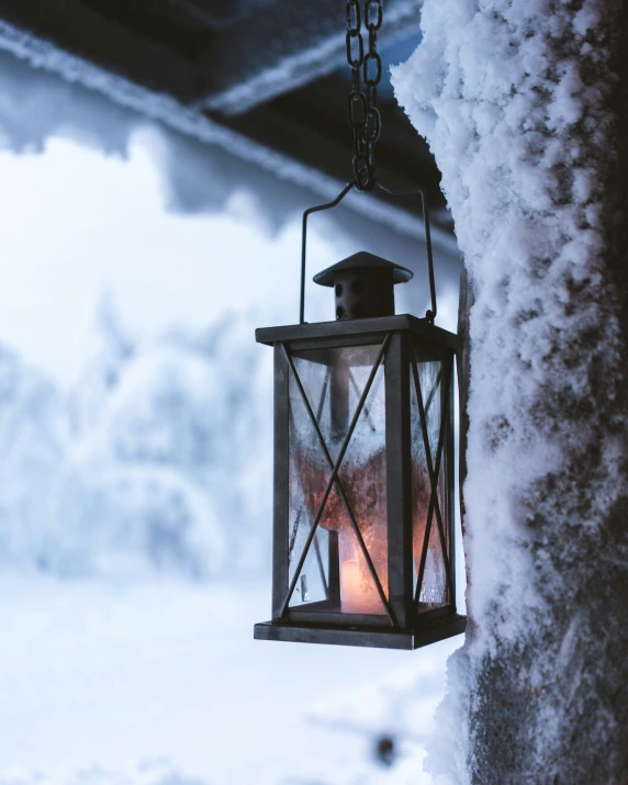 a light is hanging from a chain on snow covered roof