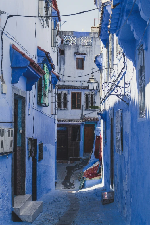 a city street with many blue buildings and blue doors