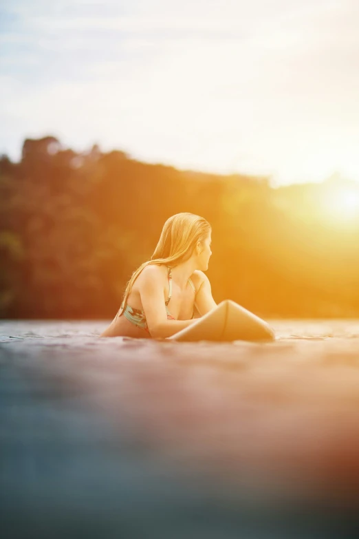 a girl in a bikini lies down on the edge of the water