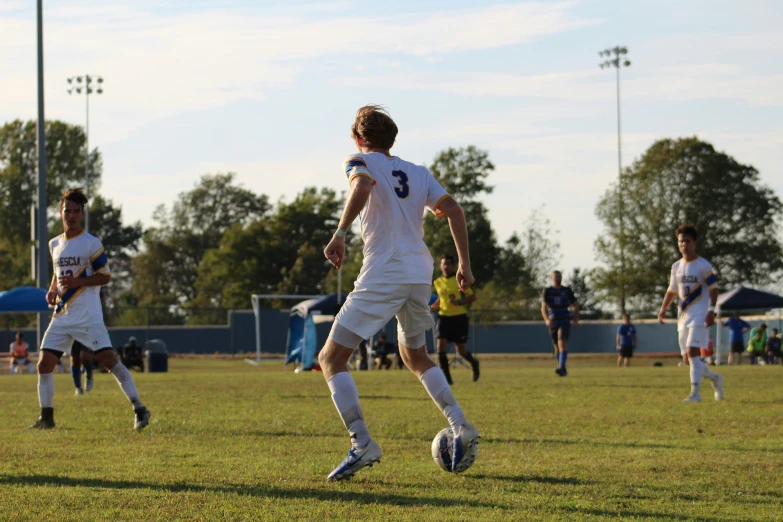 several soccer players run and kick around the field