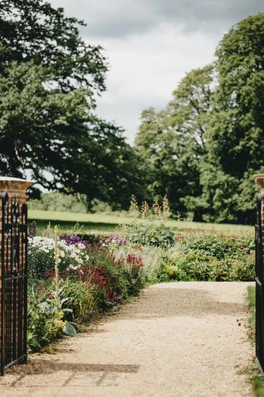 this is an open gate in a beautiful flower garden