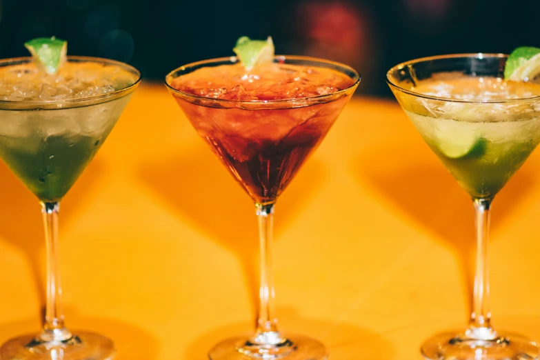 three different kinds of drinks lined up in separate glasses