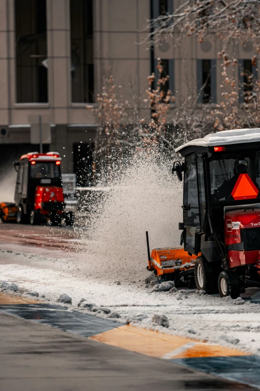 a large brusher is spraying snow from a street