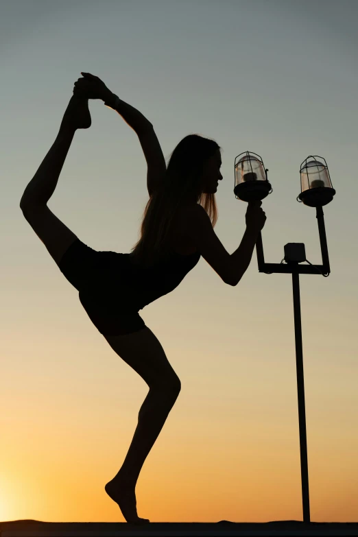 a woman doing an upward pose next to a lamp post