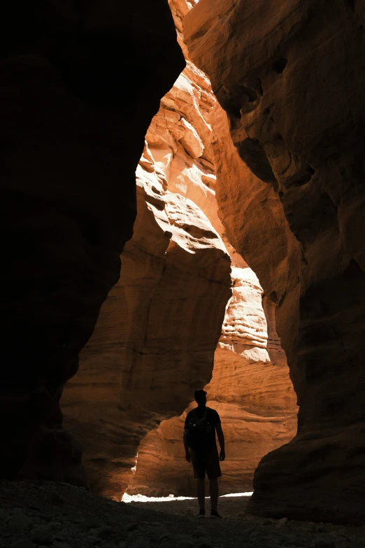 a person walking inside a rock formation in the desert