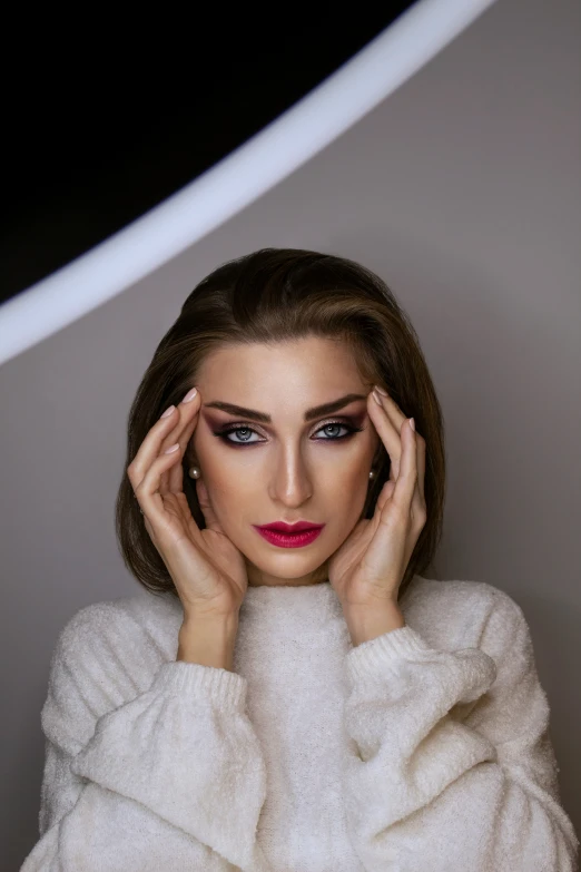 a woman with dark makeup and red lipstick covering her face