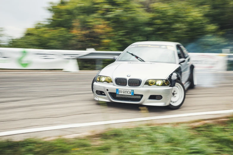 white bmw on track driving down the highway