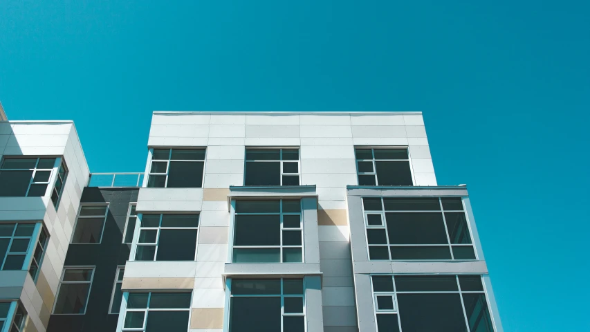 a tall white building with windows and balconies