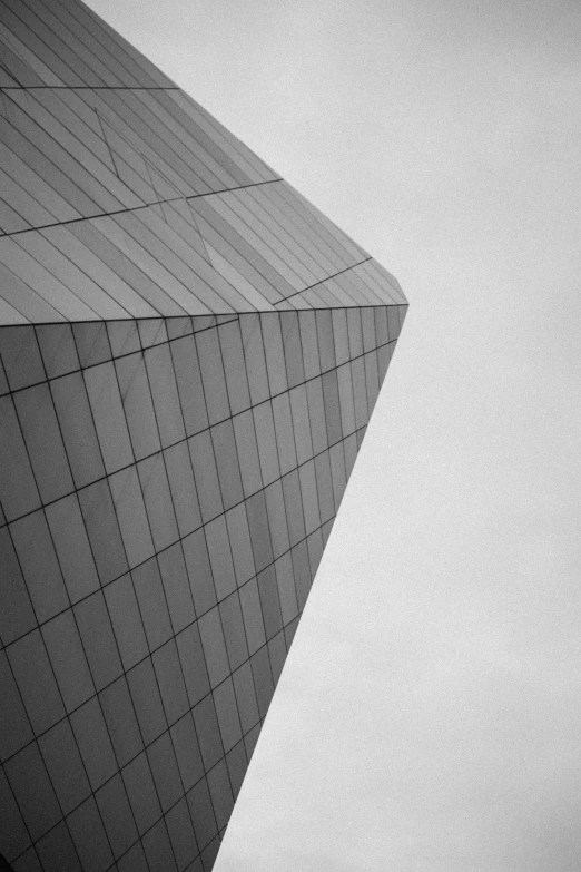 a large building sitting below a cloud filled sky