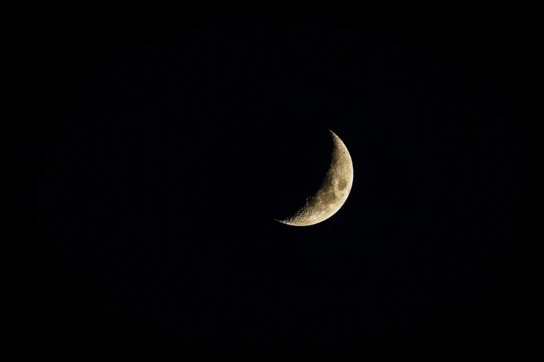 a half moon in the night sky on black