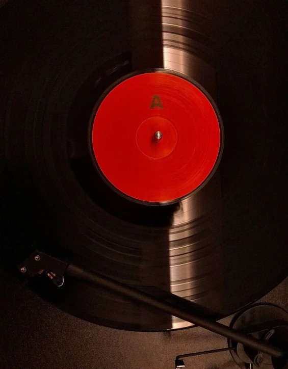 an old turntable with some red colored vinyl