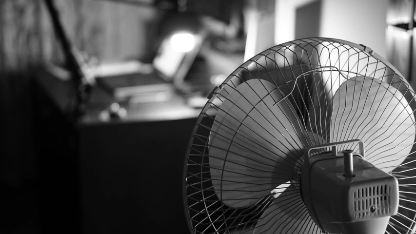 black and white image of a fan in the middle of a room