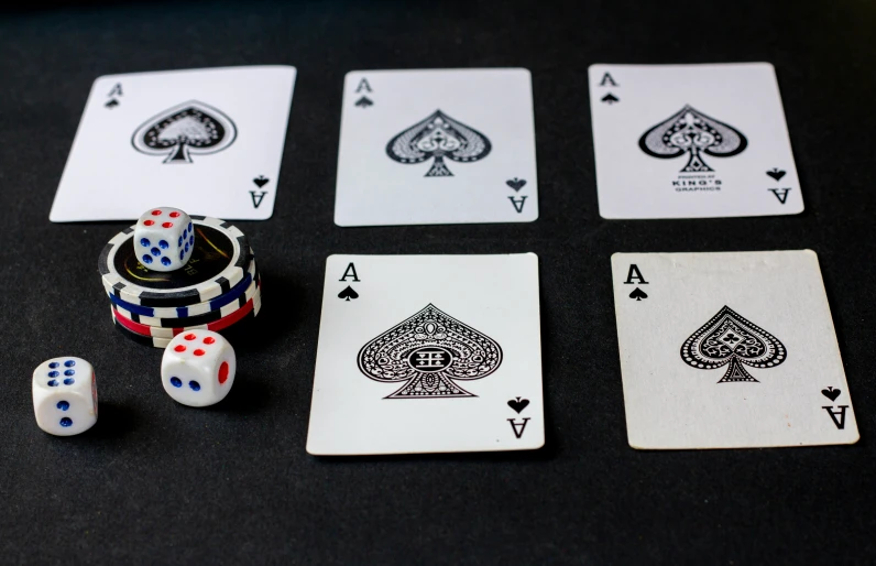 playing cards, dice and other items sit on a black surface