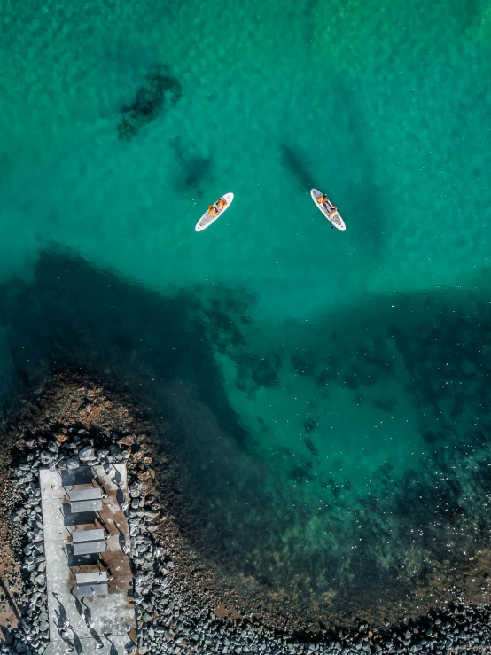 two small boats are near an island of water