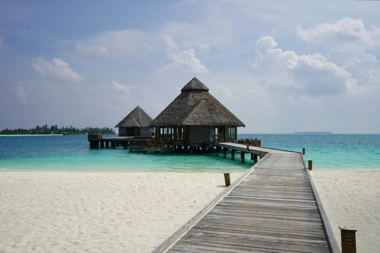 the jetty dock and a hut sits on the beach