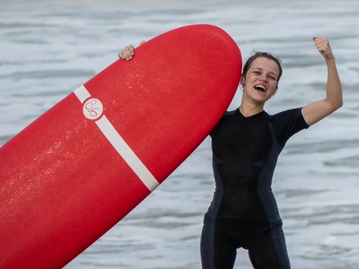 the smiling man is holding his surfboard up