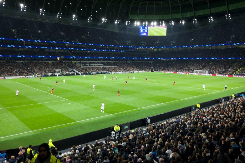 a crowd of people watching soccer on a big field